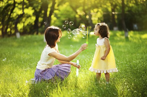 mom and daughter blowing bubbles